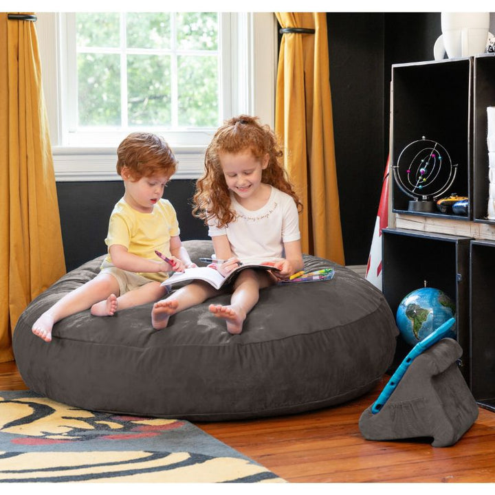 Two children reading together on a charcoal Jaxx Cocoon 4ft kids bean bag chair, a supportive sensory seat