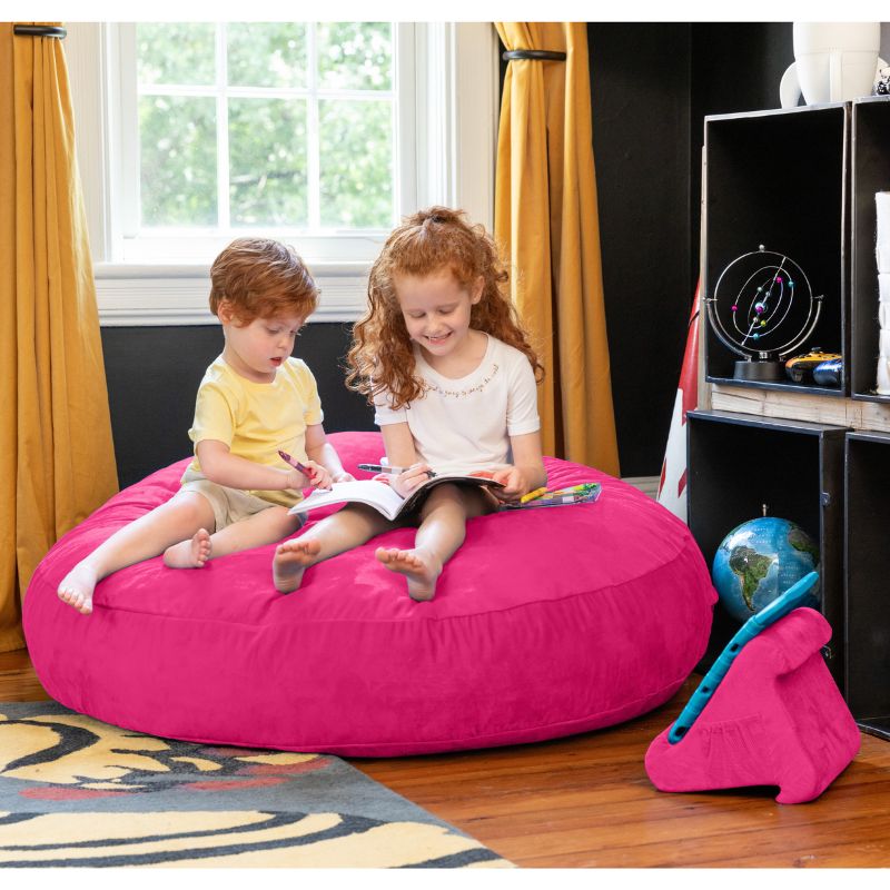 Two children reading together on a fuchsia Jaxx Cocoon 4ft kids bean bag chair, a cozy sensory crash pad for kids