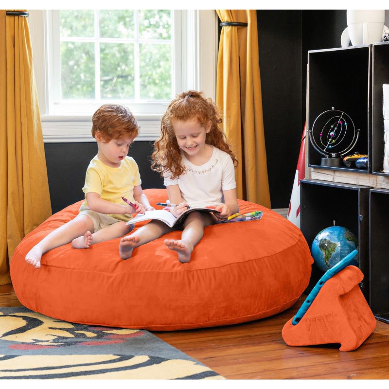 Two children reading together on an orange Jaxx Cocoon 4ft kids bean bag chair, a vibrant sensory crash pad