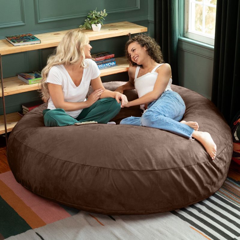 Two friends sitting together on a chocolate Jaxx Cocoon 6ft bean bag chair, a cozy giant sensory lounger