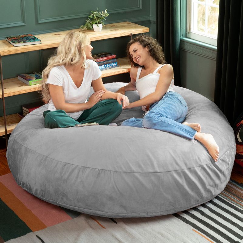 Two friends sitting together on a platinum Jaxx Cocoon 6ft bean bag chair, a neutral sensory seat