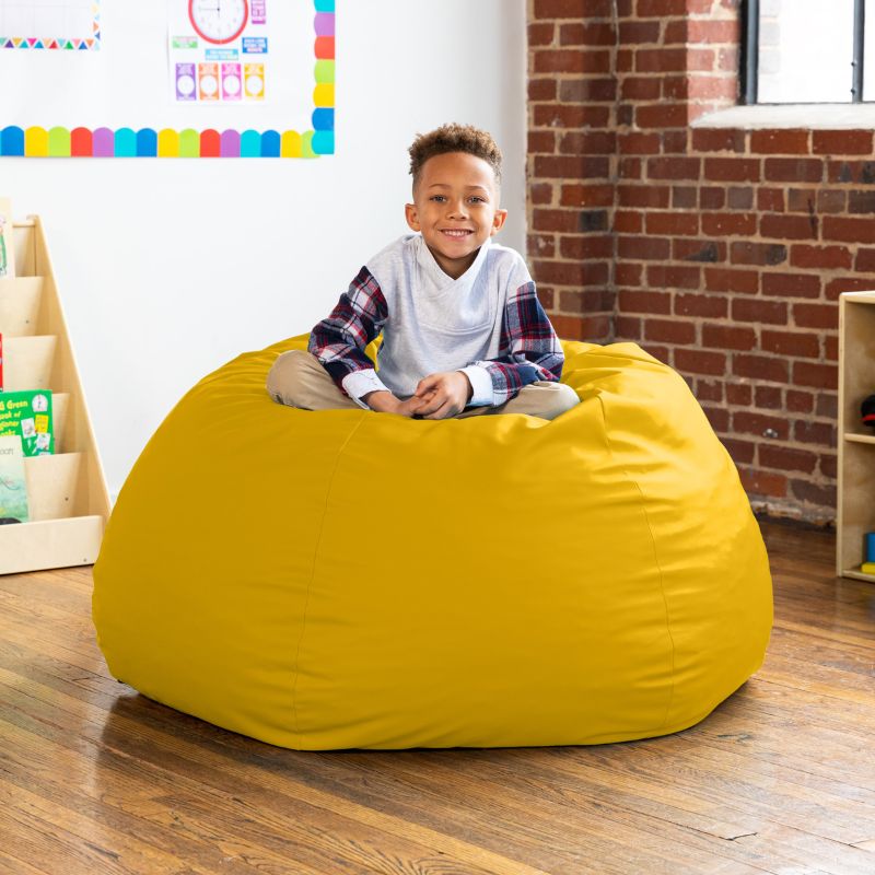 Child sitting on a yellow Jaxx Gumdrop kids bean bag chair, foam-filled classroom seating