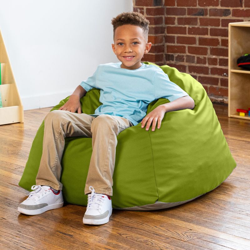 Boy sitting in a green Jaxx Gumdrop bean bag chair in a classroom setting