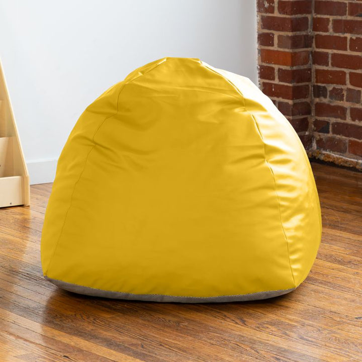 Empty yellow Jaxx Gumdrop bean bag chair in a classroom reading corner