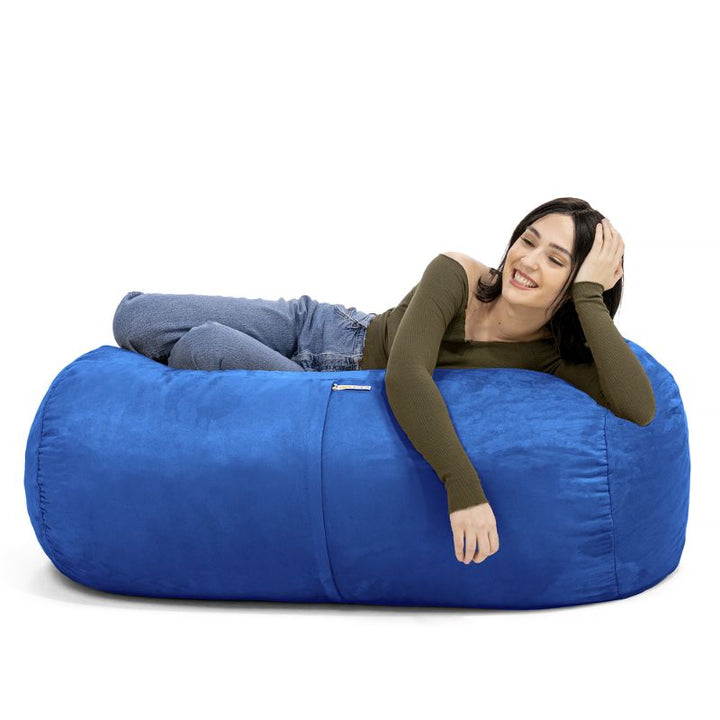 Woman leaning back on the Jaxx Lounger 4ft bean bag chair in Blue microsuede, a washable sensory seat
