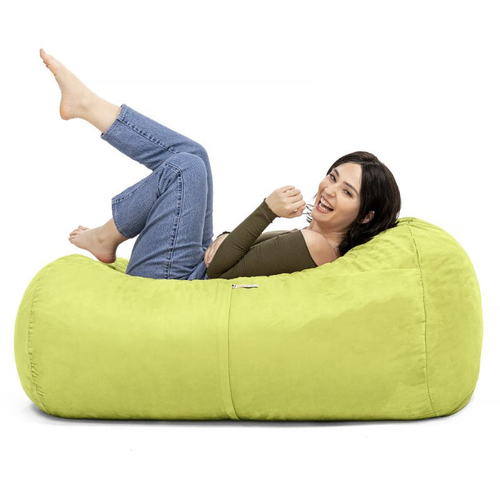 Woman relaxing on the Jaxx Lounger 4ft bean bag chair in Green microsuede, a washable sensory seat