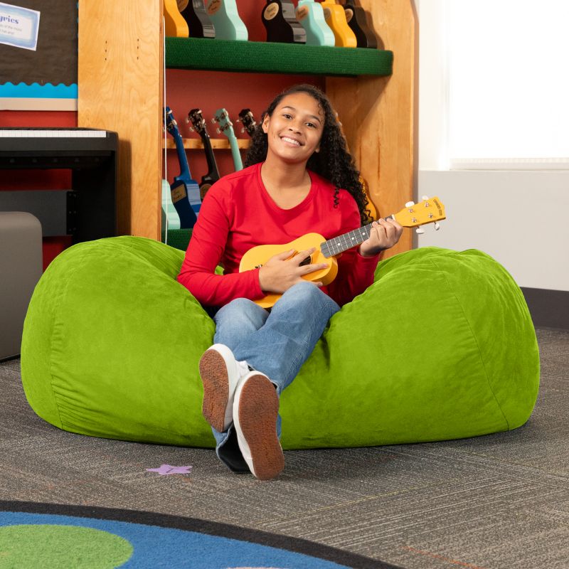 Teen playing ukulele on the Jaxx Lounger 4ft bean bag chair in Green microsuede, a washable calm corner seat
