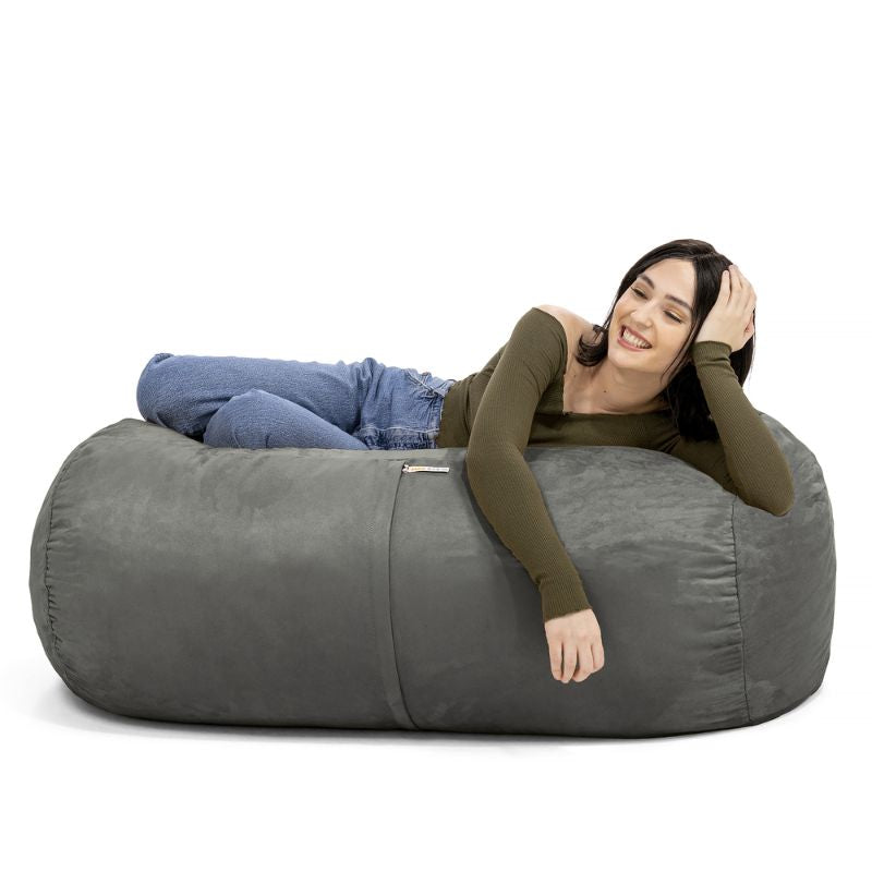 Woman leaning back on the Jaxx Lounger 4ft bean bag chair in Grey microsuede, a washable deep pressure seat