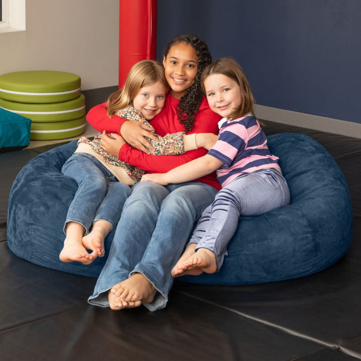 Three children sharing the Jaxx Lounger 4ft bean bag chair in Navy microsuede, a roomy calm corner seat