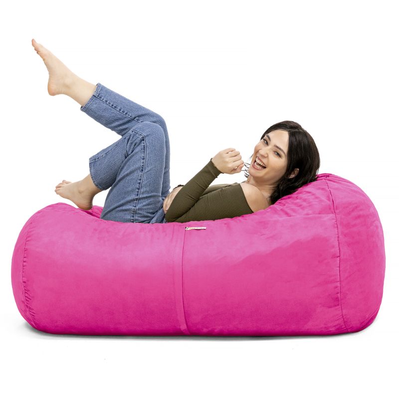 Woman relaxing on the Jaxx Lounger 4ft bean bag chair in Pink microsuede, a washable deep pressure seat
