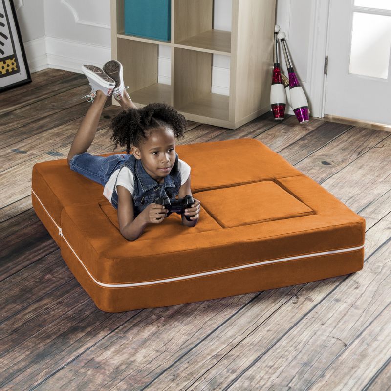 Jaxx Zipline kids convertible loveseat in orange microsuede in bed mode, a modular play sofa for lounging and play