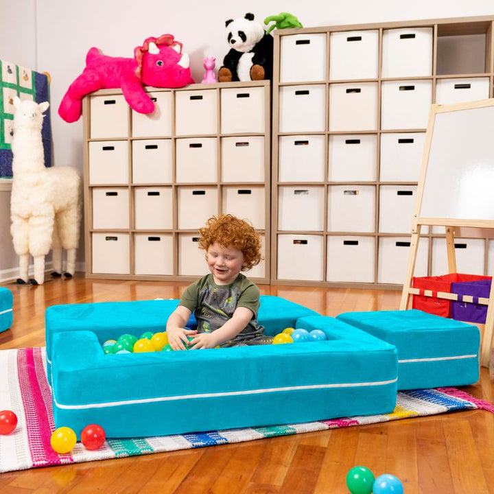 Jaxx Zipline kids convertible loveseat in teal microsuede arranged as a ball pit, a modular play sofa for imaginative play