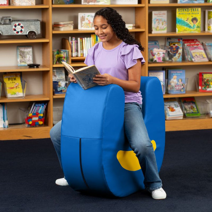 A child reading while seated on the Jaxx Zipline Loveseat, with the cover's zipper closure visible on the side