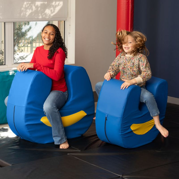 Two children playing actively on paired Jaxx Zipline Loveseat units, demonstrating movement and open-ended play