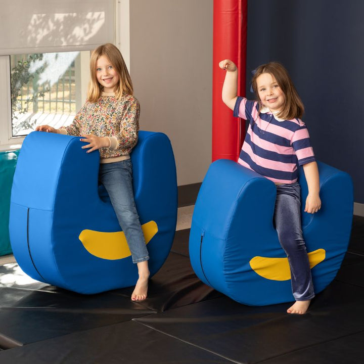 Two children seated together on paired Jaxx Zipline Loveseat units, showing the pieces used side by side