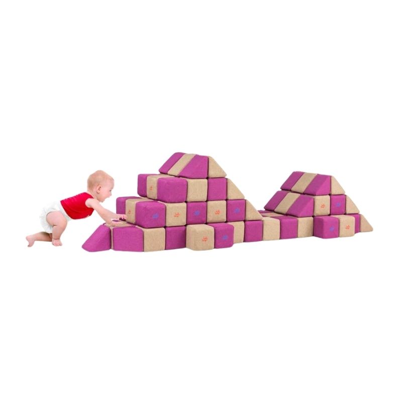 A baby crawls toward a mountain-shaped structure built from JollyHeap Basic Set magnetic foam blocks, showing this soft play set's use with the youngest builders.