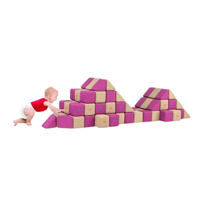 A baby crawls toward a mountain-shaped structure built from JollyHeap Basic Set magnetic foam blocks, showing this soft play set's use with the youngest builders.