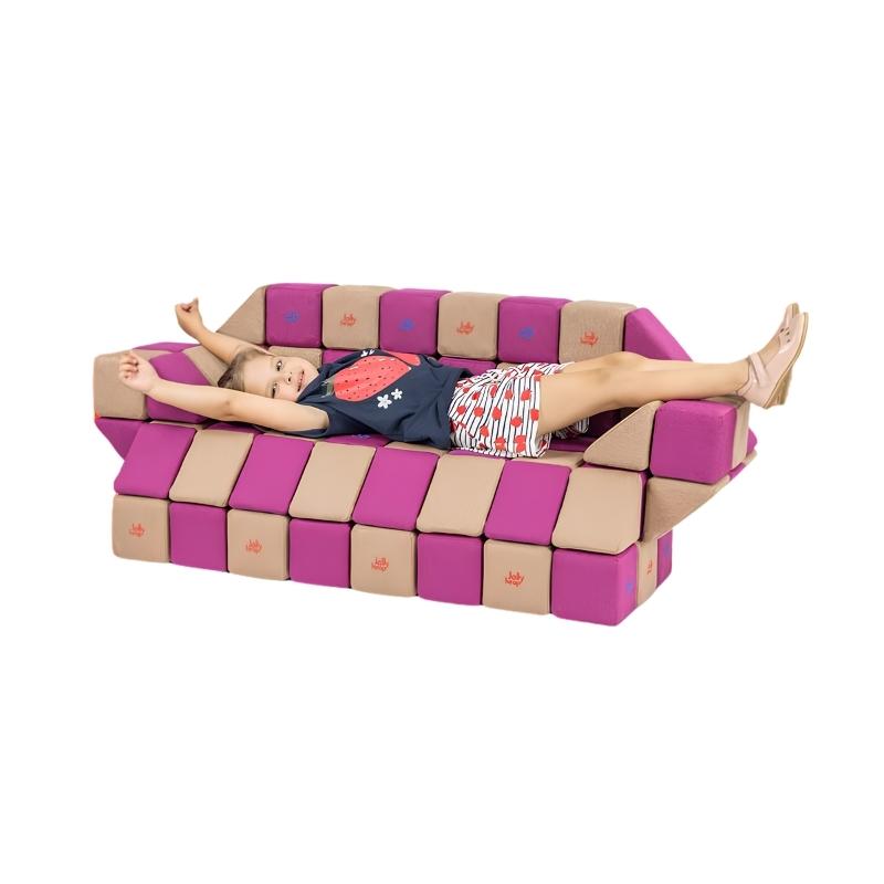 A child lies across a couch built from JollyHeap Basic Set magnetic foam blocks, showing how this soft play block set doubles as furniture for classrooms and homes.