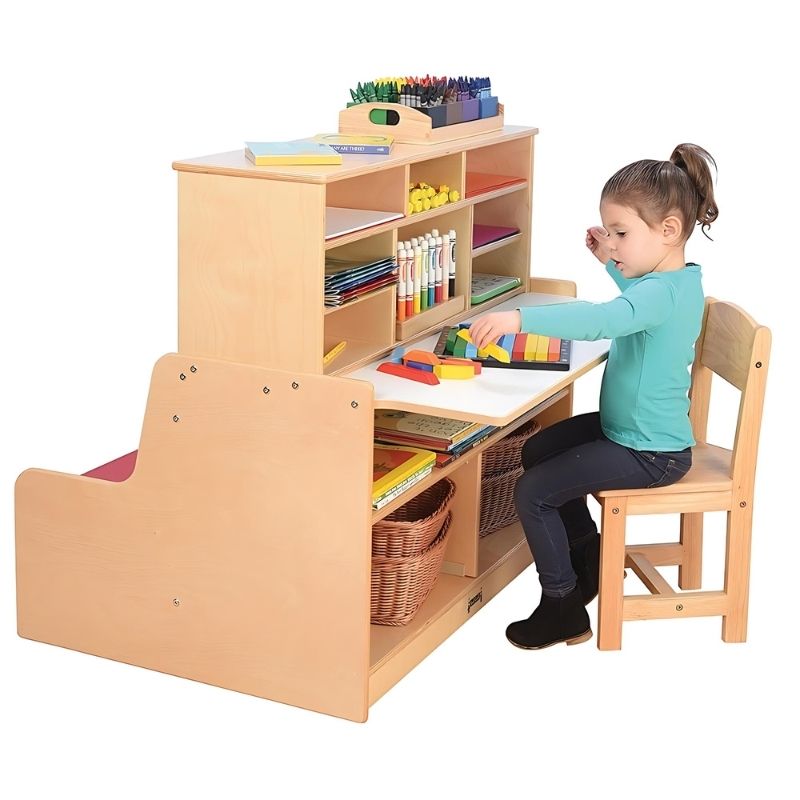 Child using the writing desktop of the Jonti-Craft Literacy Station, showing the child-height desk surface of this all-in-one Baltic Birch classroom reading and writing centre