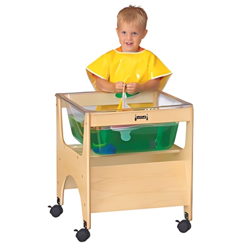 Child actively playing at the Jonti-Craft See Thru Mini Sensory Table 24-1/2" High showing the compact clear acrylic tub and preschool standing height of this GREENGUARD Gold certified sensory table