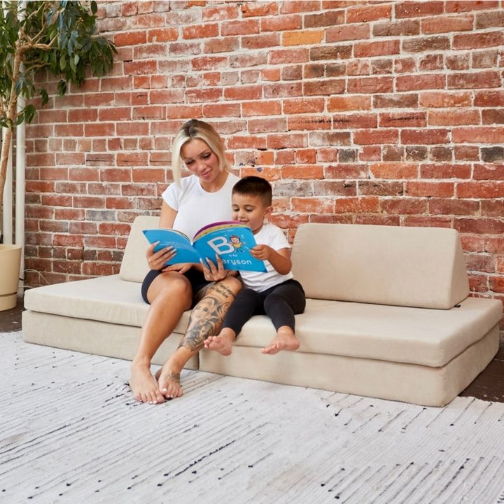 Parent and child reading together on the Kiddie Couch in Beige, showing the play couch supporting calm shared sensory and bonding experiences