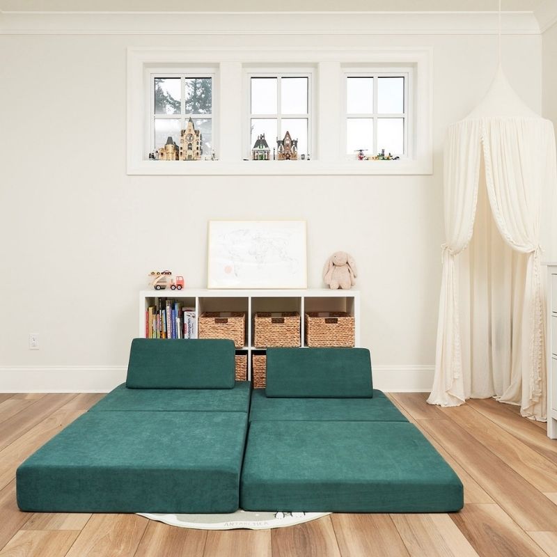Kiddie Couch in Emerald Green arranged as a bed configuration, showing the modular play couch's versatility for rest and sensory comfort