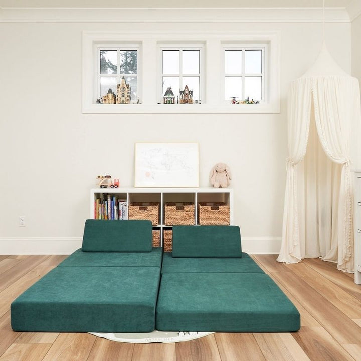 Kiddie Couch in Emerald Green arranged as a bed configuration, showing the modular play couch's versatility for rest and sensory comfort