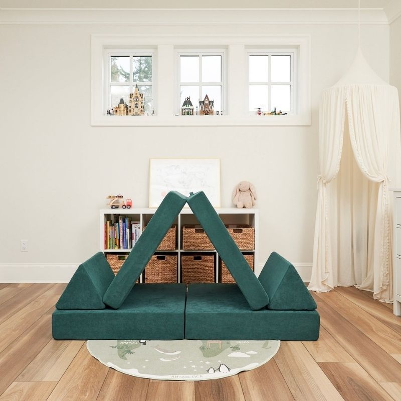 Angled view of the Kiddie Couch in Emerald Green with cushion arrangement showing a creative modular build configuration