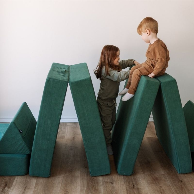 Two children actively stacking and building with the Kiddie Couch in Emerald Green, engaging gross motor skills and proprioceptive input
