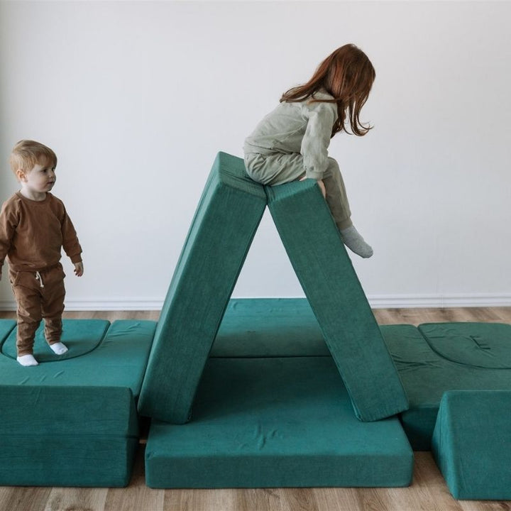 Two children playing in a fort built from the Kiddie Couch in Emerald Green, supporting collaborative imaginative and sensory play