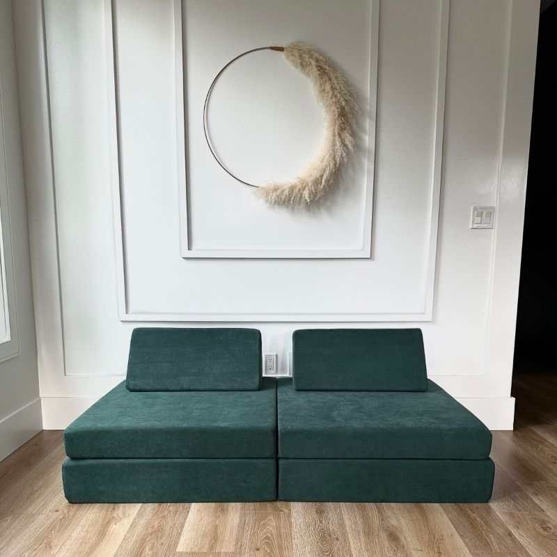 Front view of the Kiddie Couch modular play couch in Emerald Green showing the full assembled four-piece foam configuration