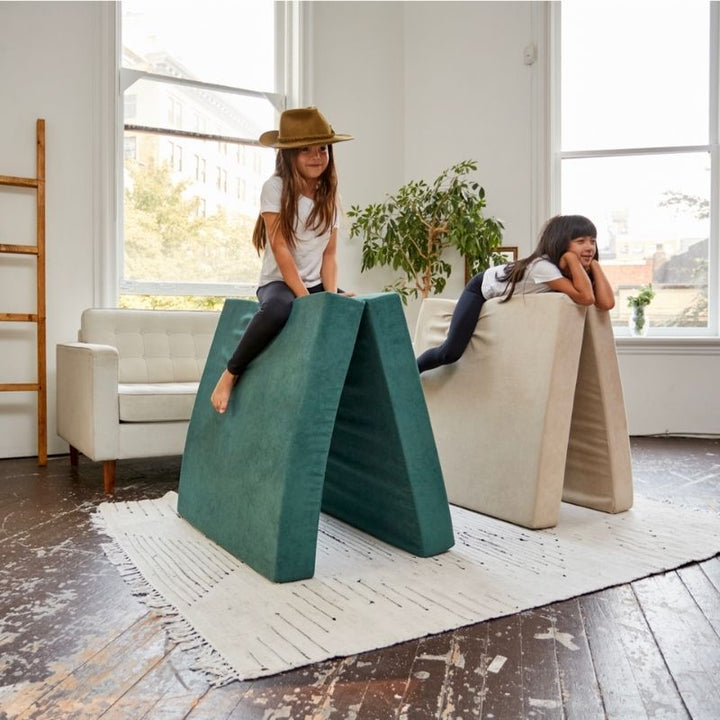 Two children playing horse riding on the Kiddie Couch in Green and Beige, showing active imaginative and gross motor sensory play