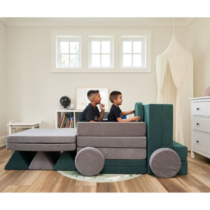 Children using the Kiddie Couch in Grey and Green to build a truck shape, showing creative gross motor and imaginative play configurations