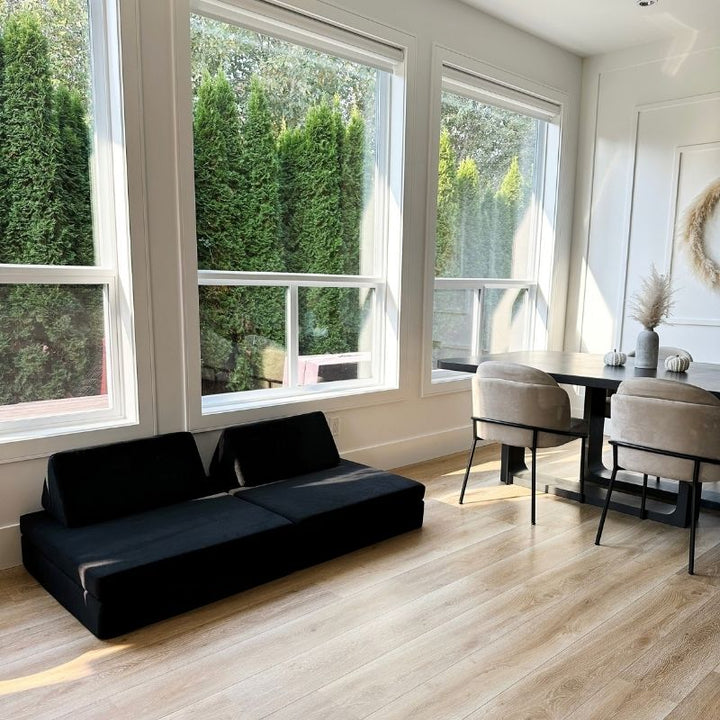 Angled view of the Kiddie Couch in Jet Black in a dining room setting, showing the modular play couch as versatile home furniture