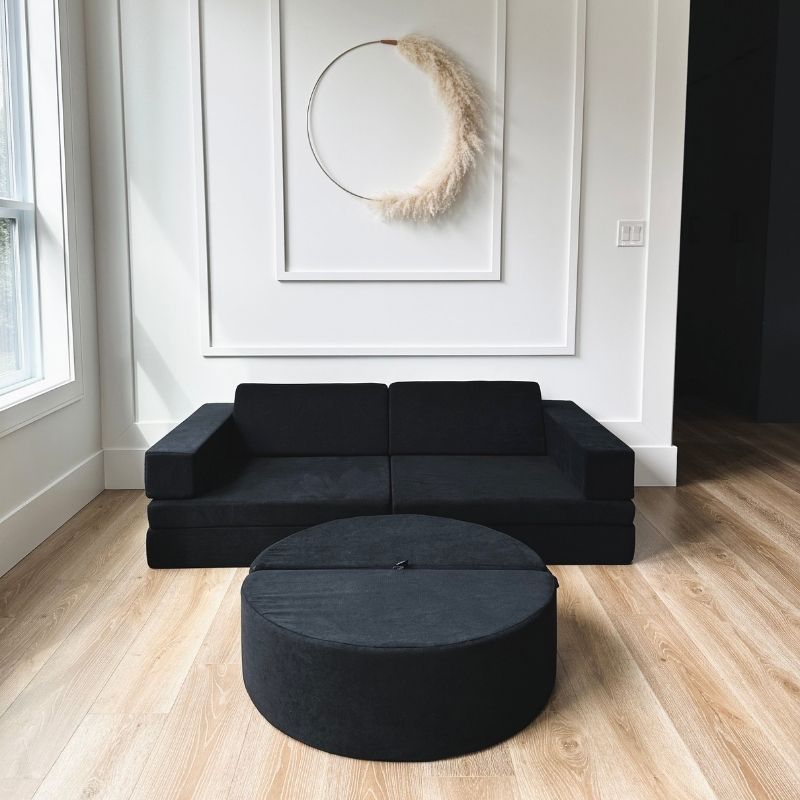 Three children jumping on the Kiddie Couch in Emerald Green, showing the play couch supporting group active play and vestibular development
