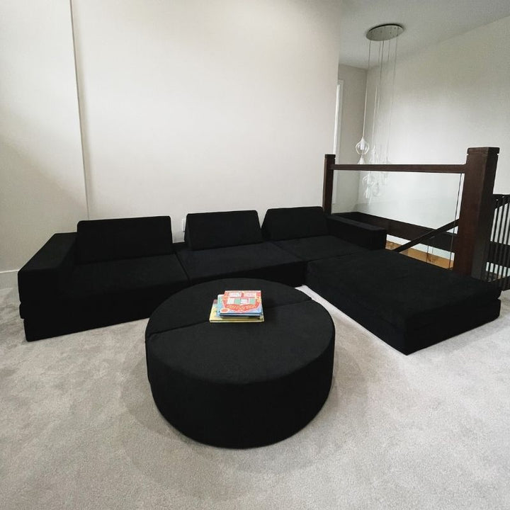 Landscape view of the Kiddie Couch in Jet Black styled in a family living room setting