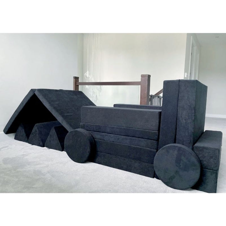 Children using the Kiddie Couch in Jet Black to build a train shape, engaging imaginative play and creative gross motor configurations