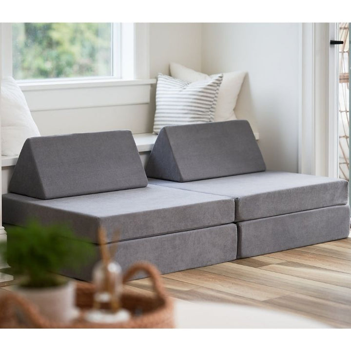 Angled view of the Kiddie Couch modular play couch in Koala Grey showing the four-piece foam assembly from the side