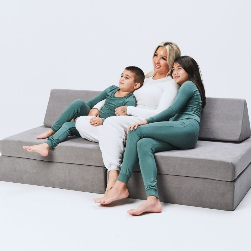 Family using the Kiddie Couch in Koala Grey together, showing the modular play couch as shared furniture for parents and children