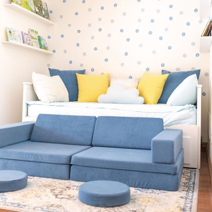 Landscape view of the Kiddie Couch in Pacific Blue styled in a child's bedroom, showing the play couch in a home sleep and play setting