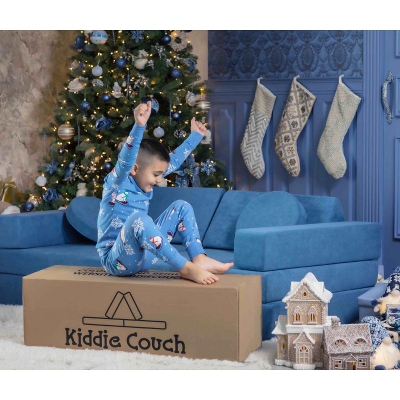 Happy child with the Kiddie Couch in Pacific Blue as a Christmas present, showing the modular sensory play couch as a meaningful gift