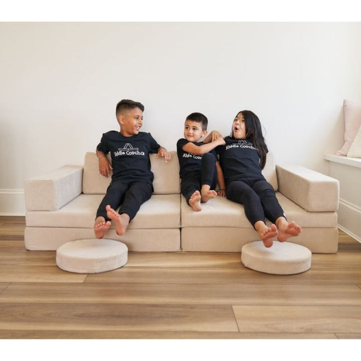 Children sitting together on the Kiddie Couch in Sand Beige, showing the play couch as comfortable everyday kids furniture