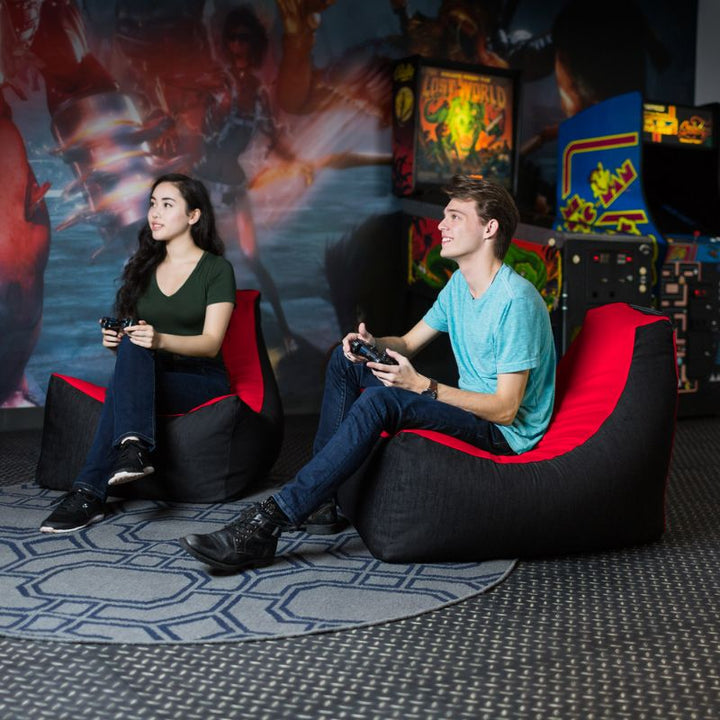 Two teens sit in matching Jaxx Pixel gaming bean bag chairs in red, classroom and library seating for kids