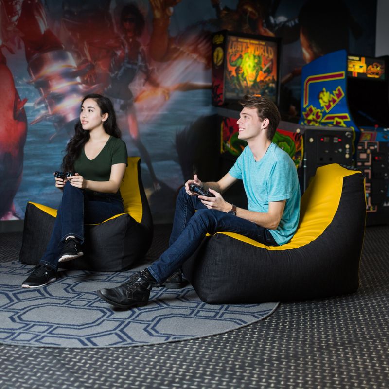 Two teens sit in matching Jaxx Pixel gaming bean bag chairs in yellow, classroom and library seating for kids