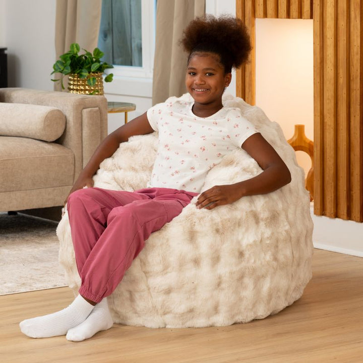 Child sitting upright in the Raven-Symoné Lil' Cuddler kids bean bag lounger in Lush Fur Phantom Cream