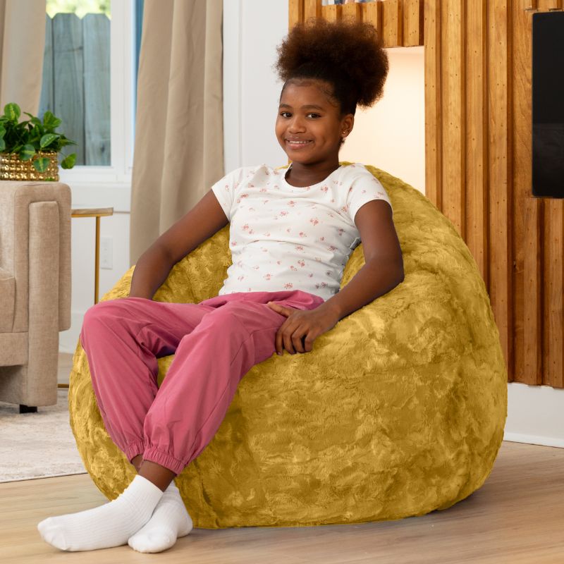 Child sitting upright in the Raven-Symoné Lil' Cuddler kids bean bag lounger in Lush Fur Gold