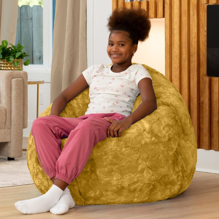 Child sitting upright in the Raven-Symoné Lil' Cuddler kids bean bag lounger in Lush Fur Gold