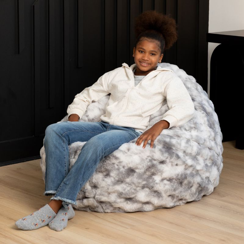Child sitting upright in the Raven-Symoné Lil' Cuddler kids bean bag lounger in Lush Fur Phantom Grey
