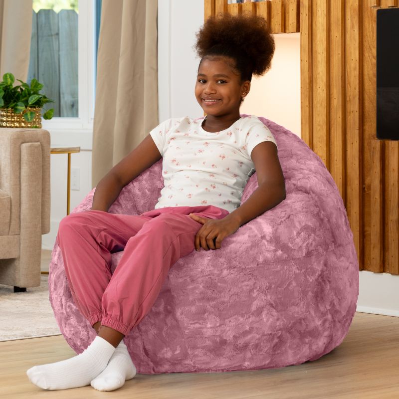 Child sitting upright in the Raven-Symoné Lil' Cuddler kids bean bag lounger in Lush Fur Wild Rose