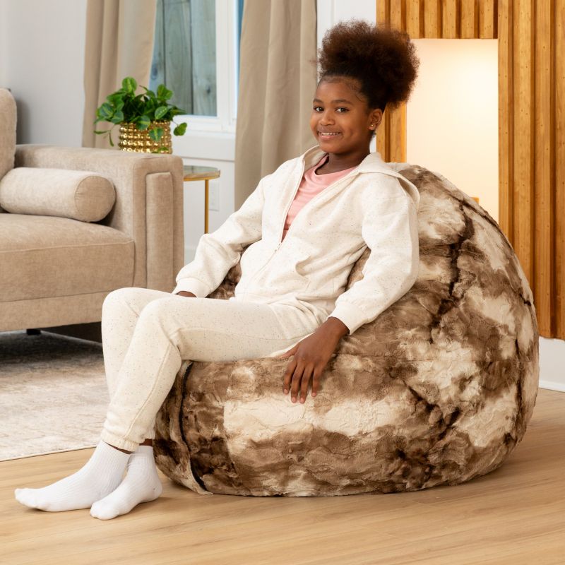 Child sitting upright in the Raven-Symoné Lil' Cuddler kids bean bag lounger in Lush Tie-Dye Fur Coca Mocha